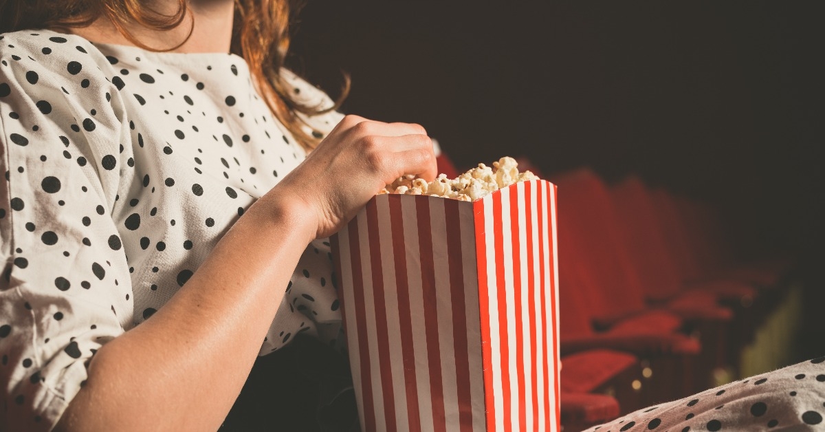 woman eating popcorn in movie theater