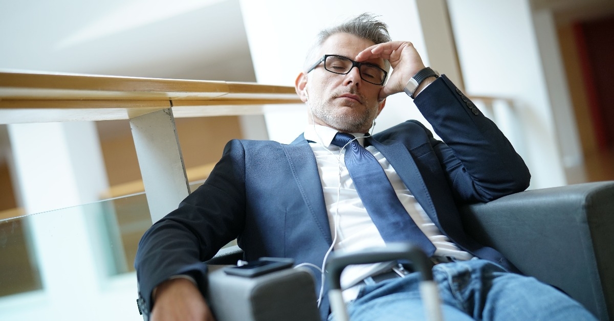 businessman taking a nap in airport departure lounge
