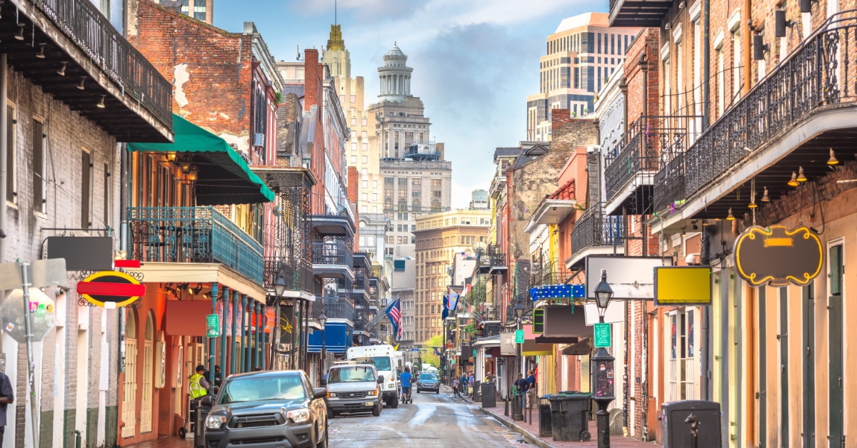 Louisiana bourbon street with cars all around the sidewalks