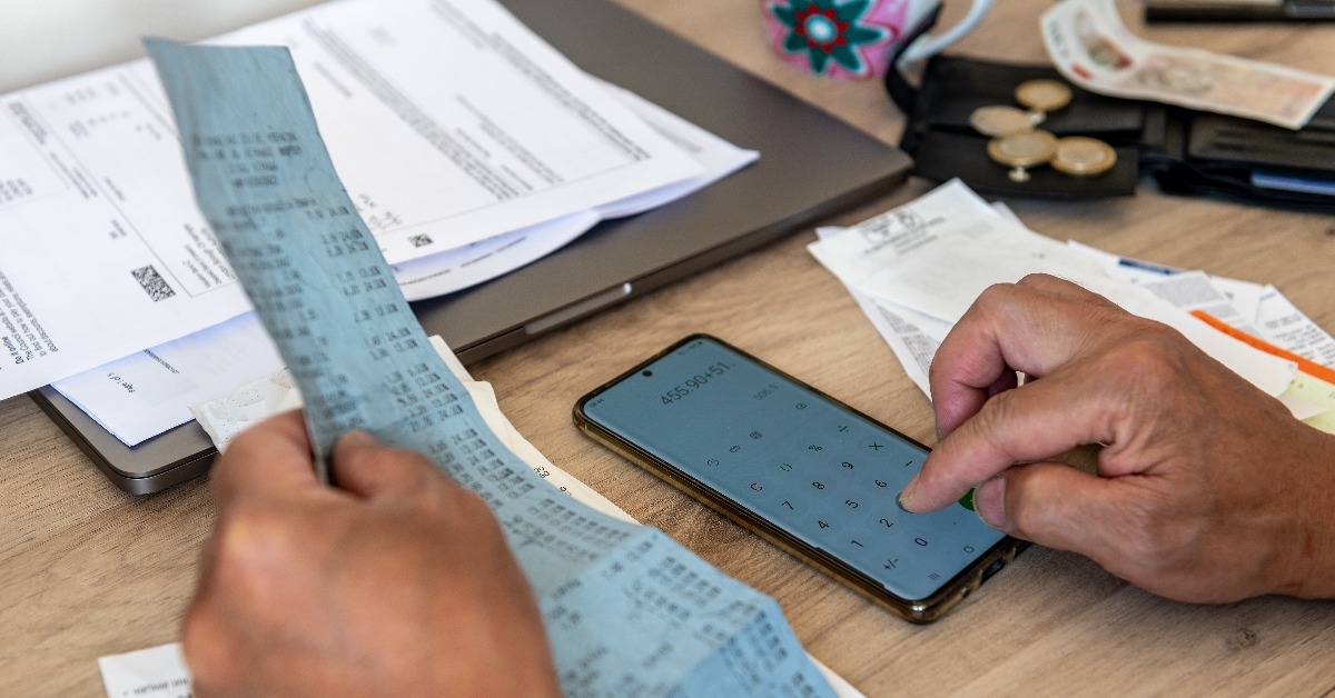 person calculating the cost of living with a phone calculator