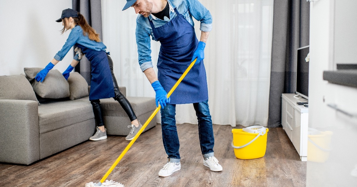 professional cleaners in blue uniform washing floor
