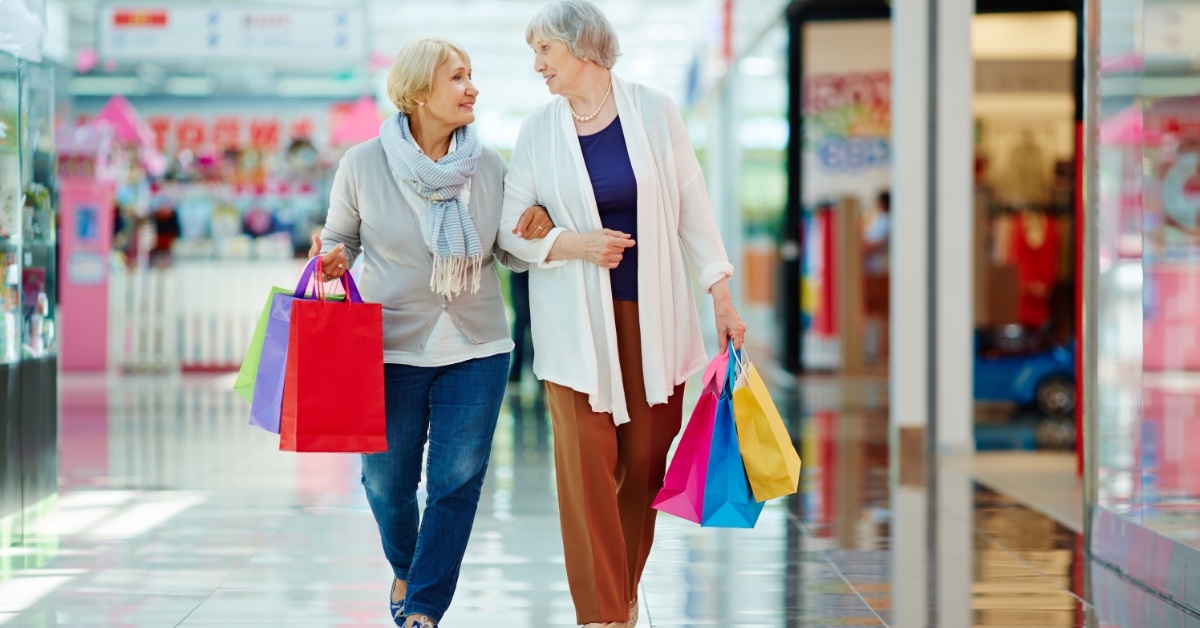 senior ladies with shopping bags walking in a mall 