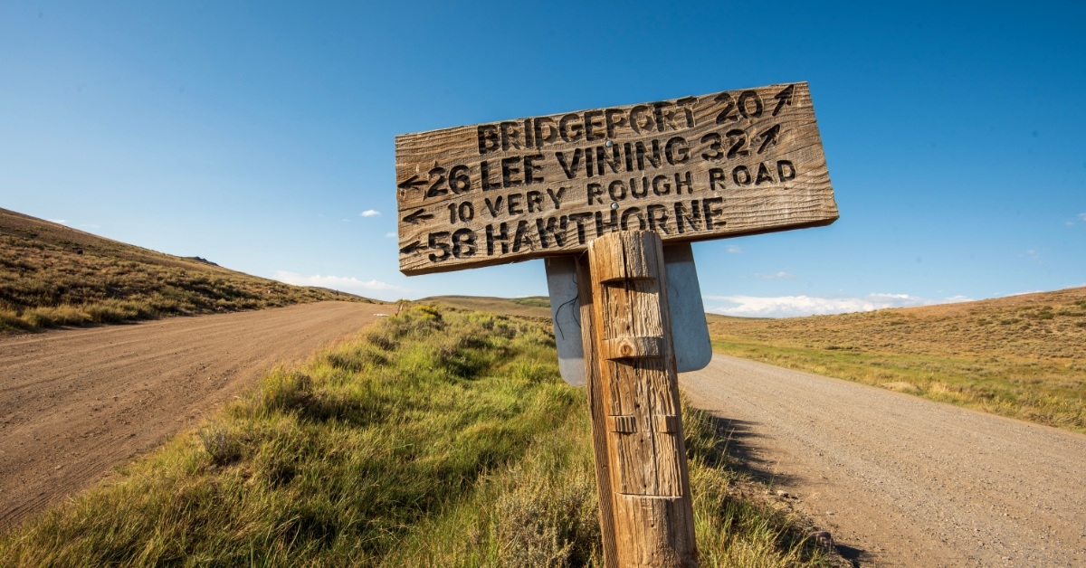 wooden road sign with direction in rural california