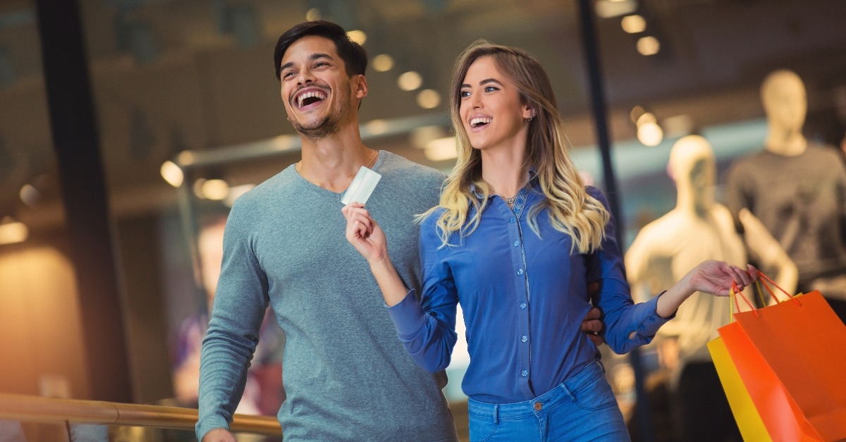 couple showing their new credit card at the mall
