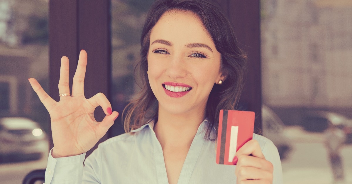 woman holding showing credit card near office store