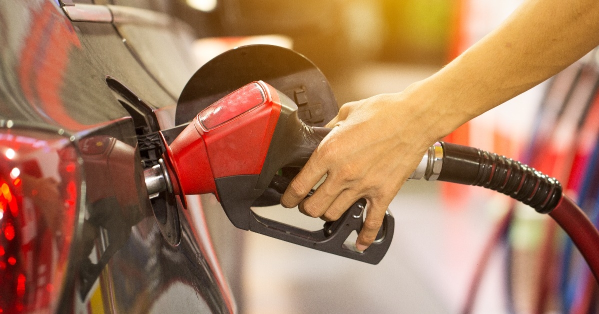man pumping gasoline fuel in car at gas station