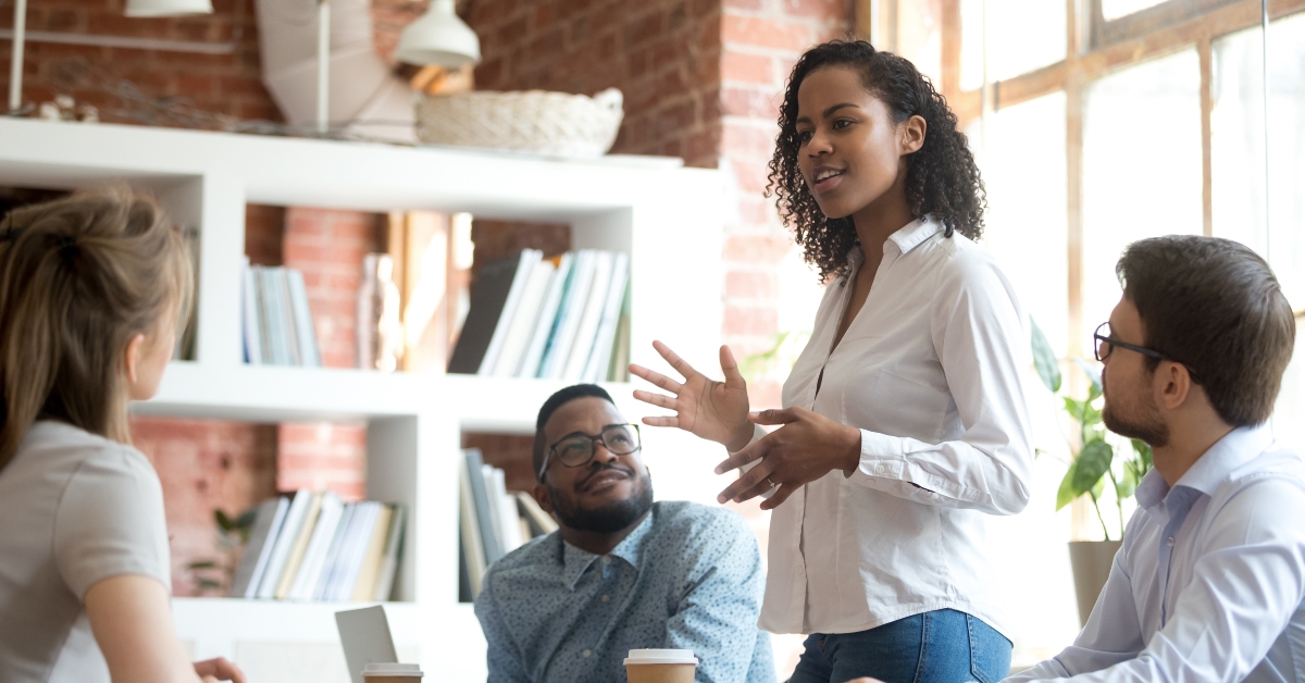 female employee speaking at diverse meeting