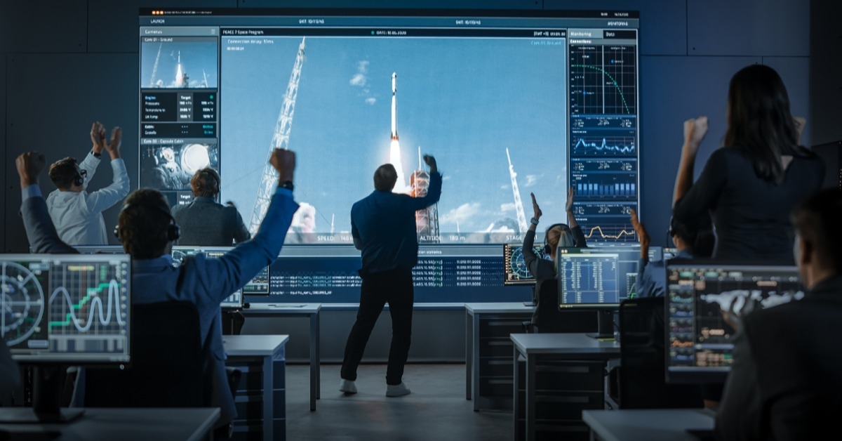 group of people in mission control center witness space rocket launch