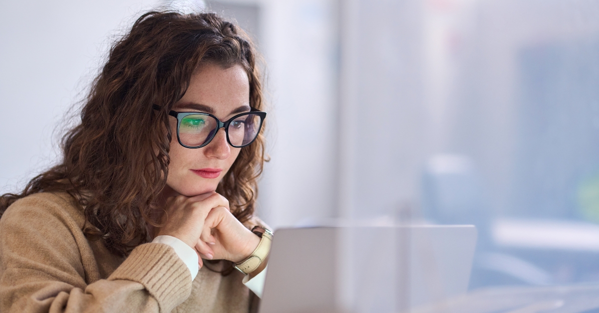 student wearing glasses using laptop