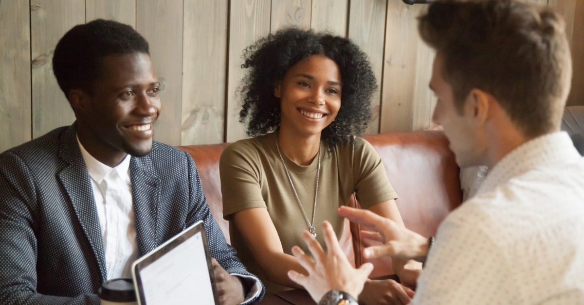 young male advisor talking to african american couple