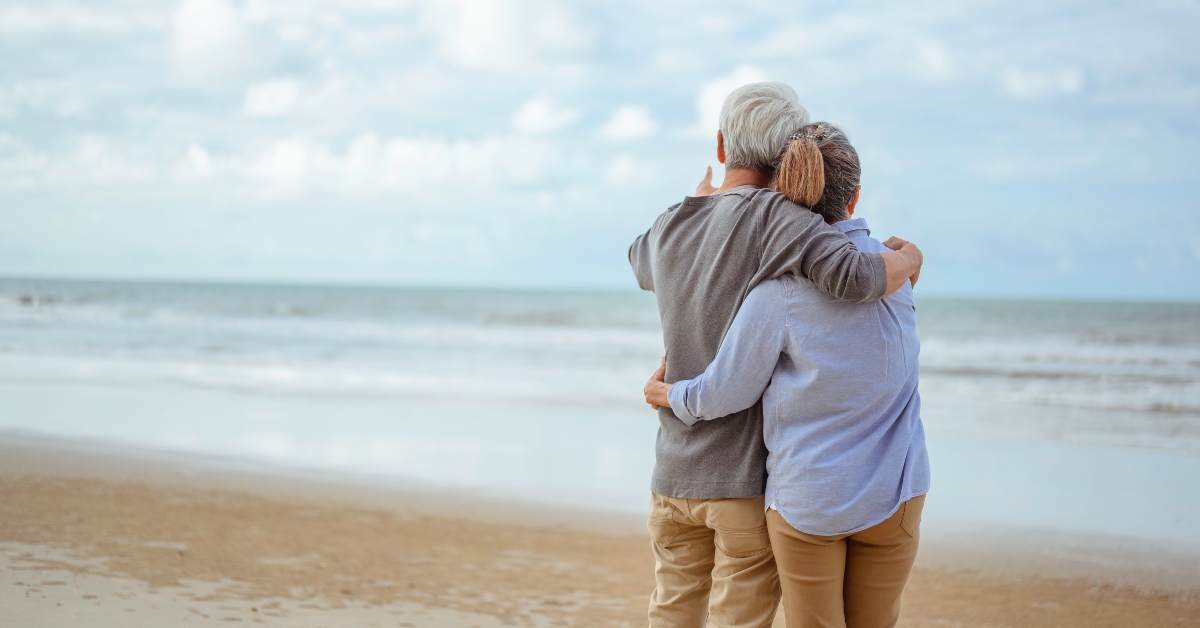 senior couple hugged each other at the beach in the morning