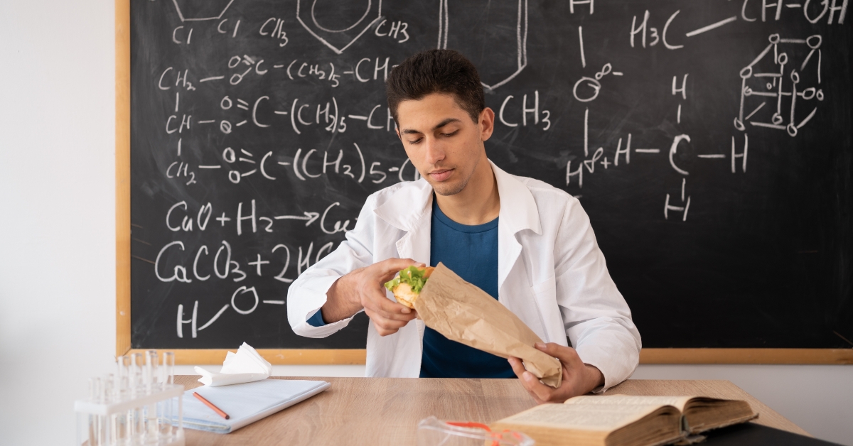chemistry teacher holding a piece of hamburger