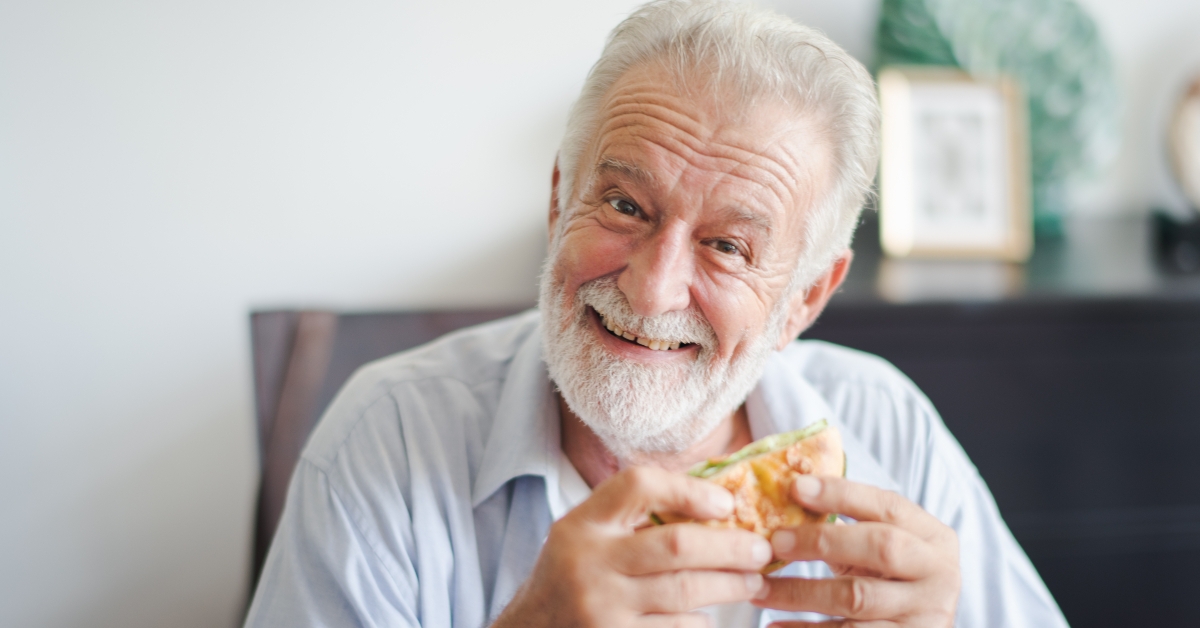 man is sitting to eat a burger at home