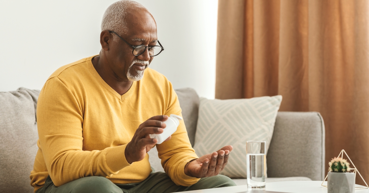 man taking medication pill at home