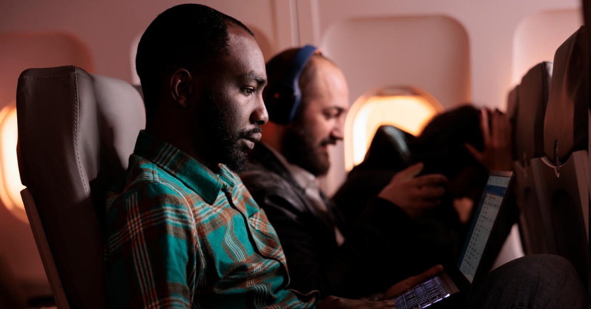 african american man using laptop in commercial airline 