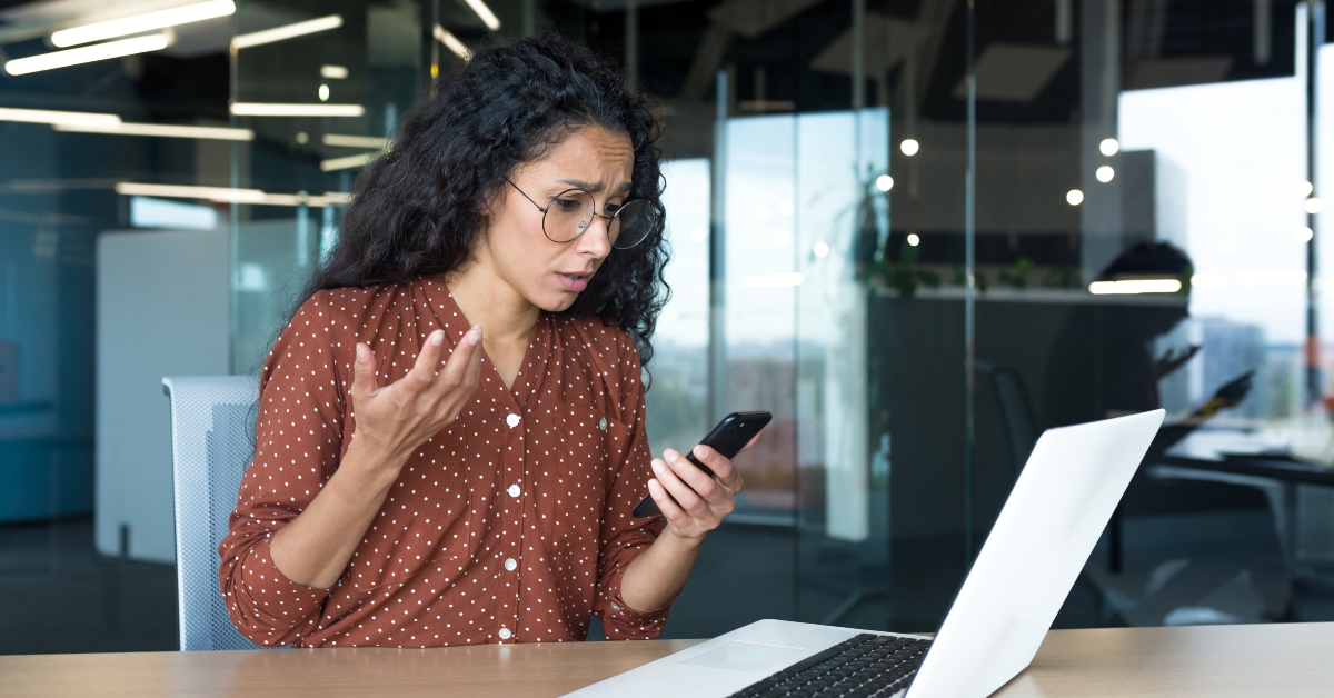 sad woman looking at phone screen
