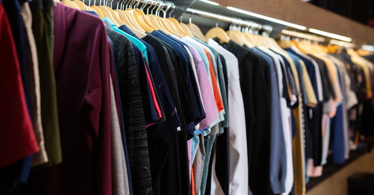 stand with various clothes in clothing boutique