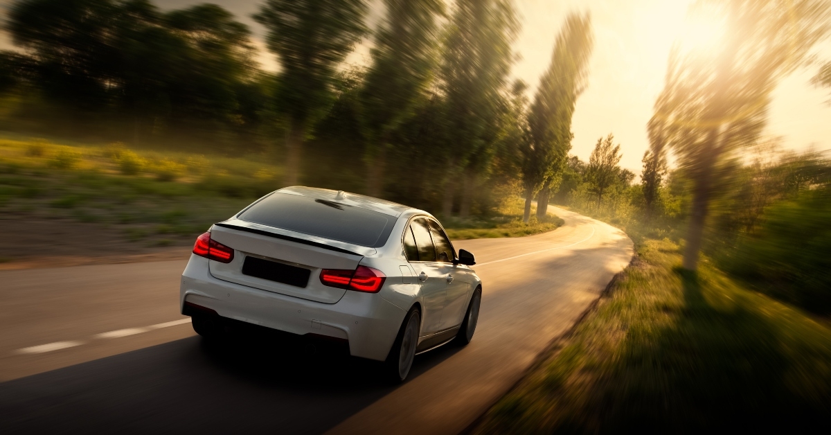 white car is driving on empty countryside