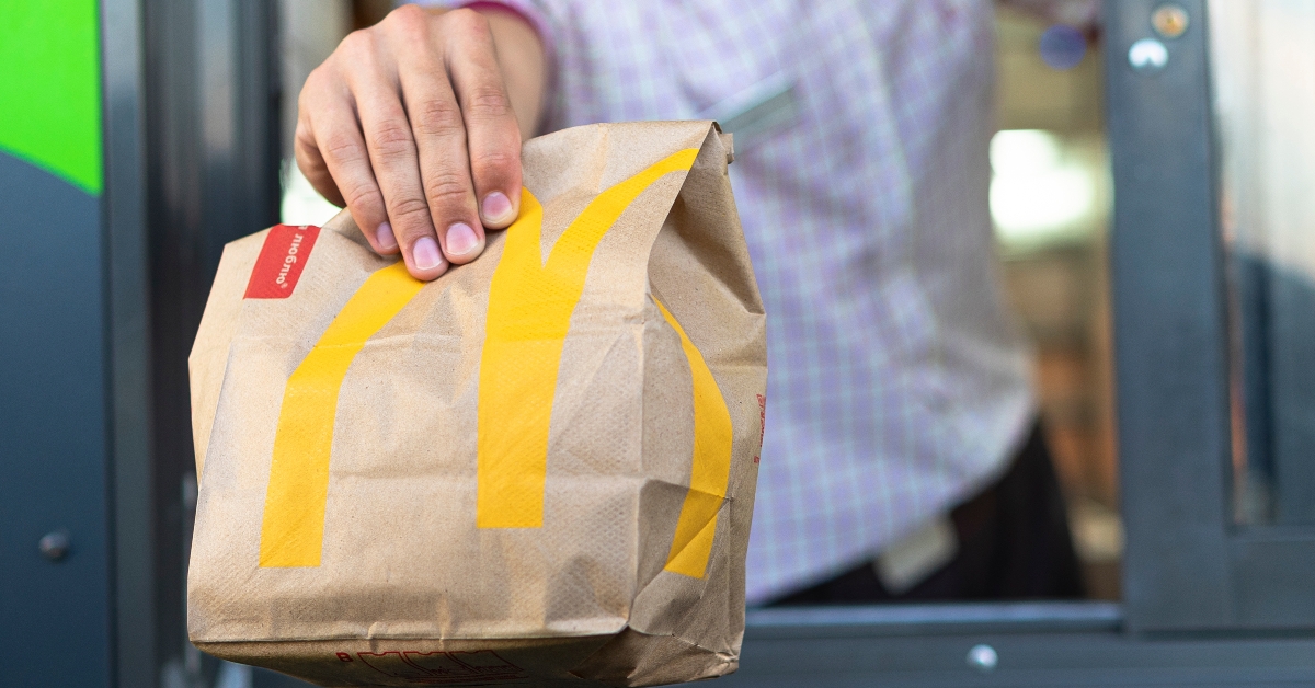 McDonald's worker holding bag of fast food