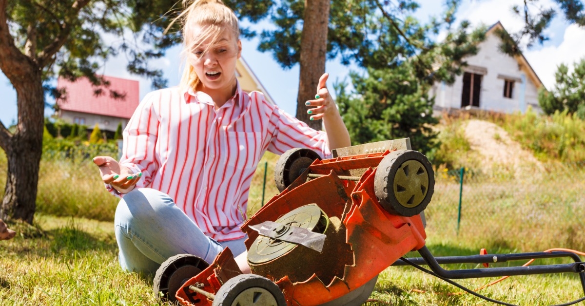 woman having issues with lawn mower
