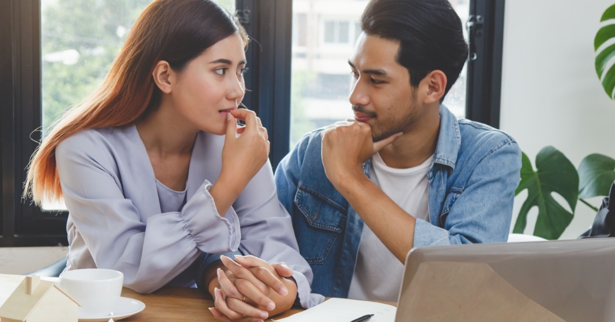 young asian couple holding hands and looking at each other