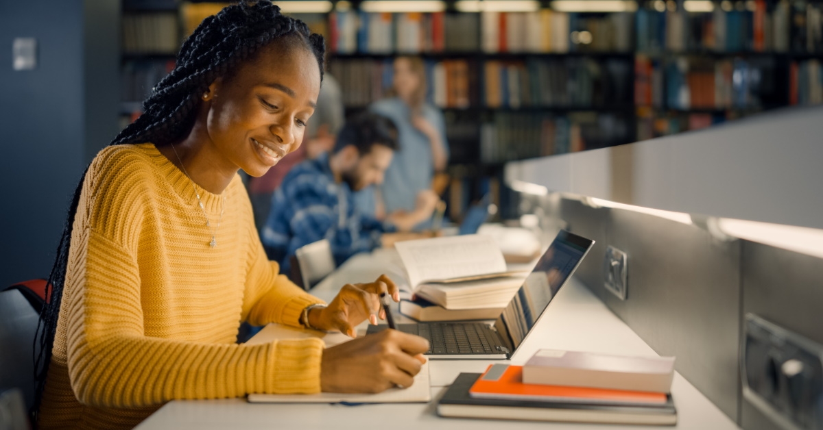 african american women writing something on paper in library