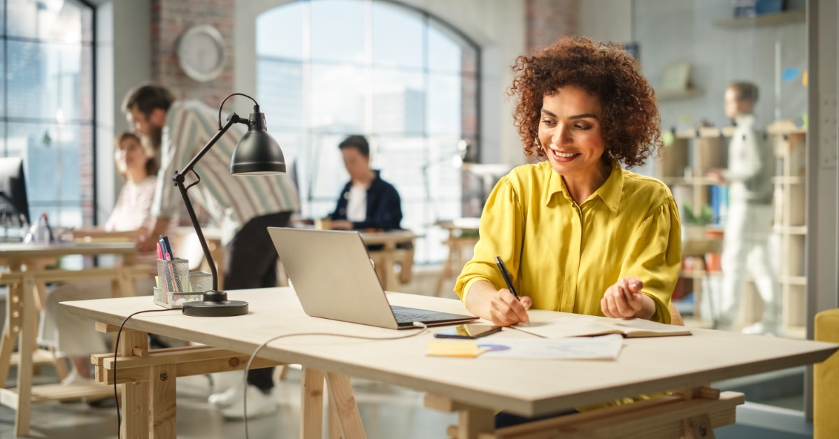 happy african woman working on laptop in office 