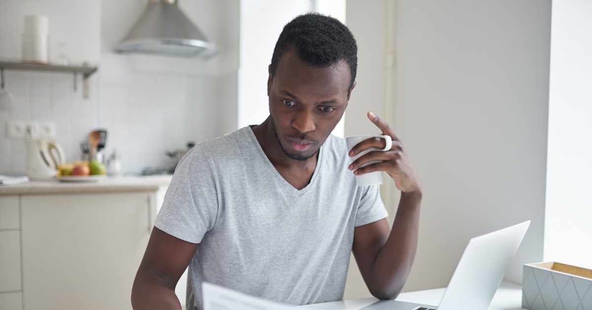 man looking at bill with concentrated puzzled expression