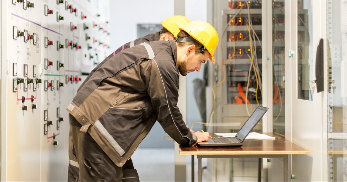maintenance engineers inspect relay protection system with laptop