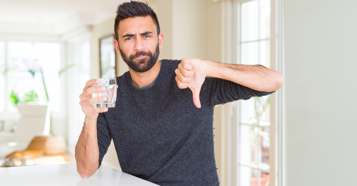  man drinking a fresh glass of water with angry face