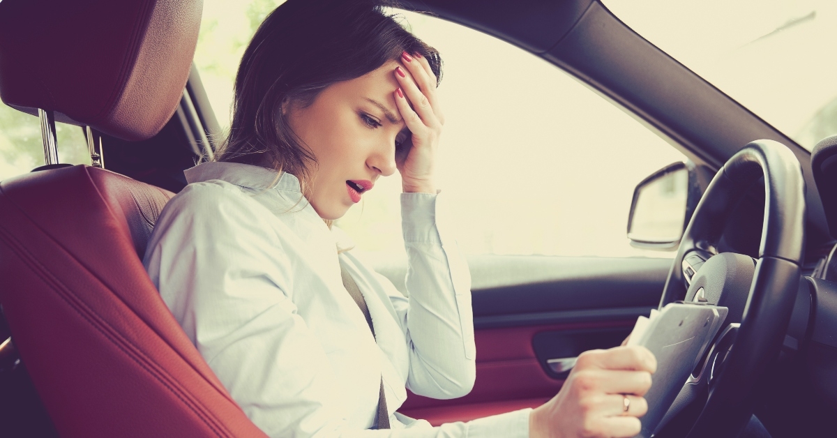 shocked woman in car with papers
