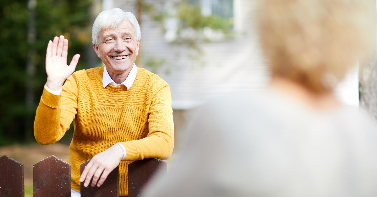 happy senior man in t shirt waving hand 