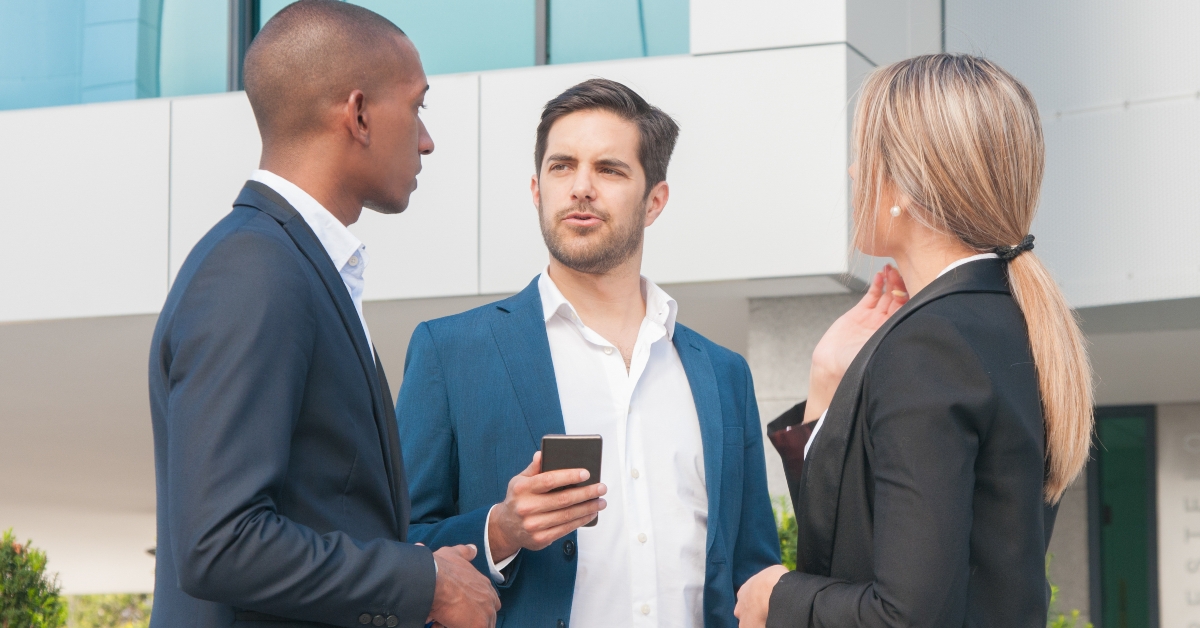 business partners discussing contract details outside office