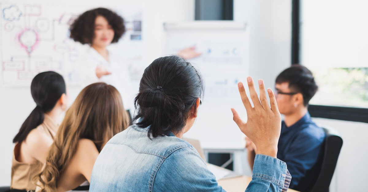 business people rising hand for asking question while meeting in office