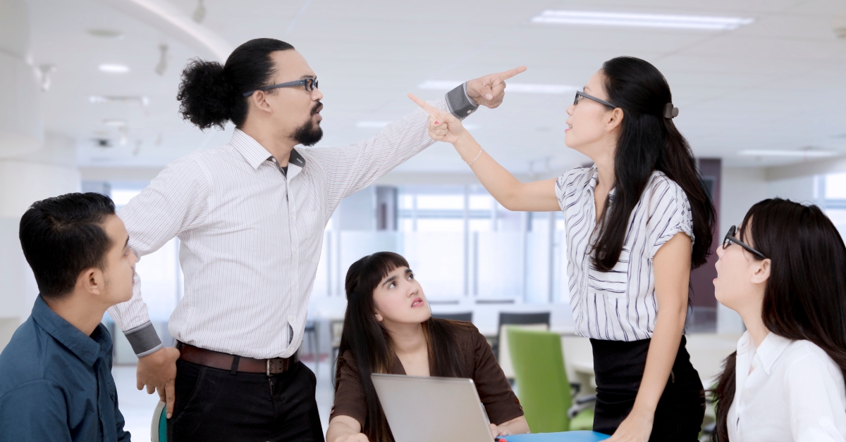 businesspeople pointing at each other having an argument 