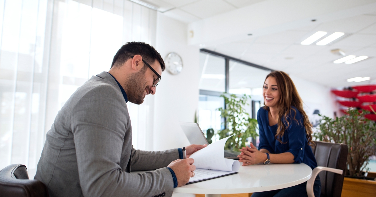 employer reading CV while candidate is smiling