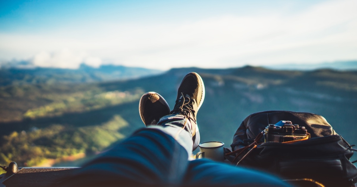 man with backpack resting while trekking