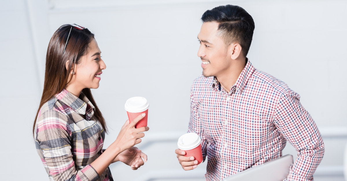 man and woman talking while drinking coffee