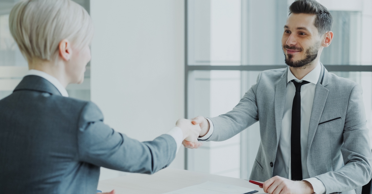 manager shaking hand to female candidate after having job interview 