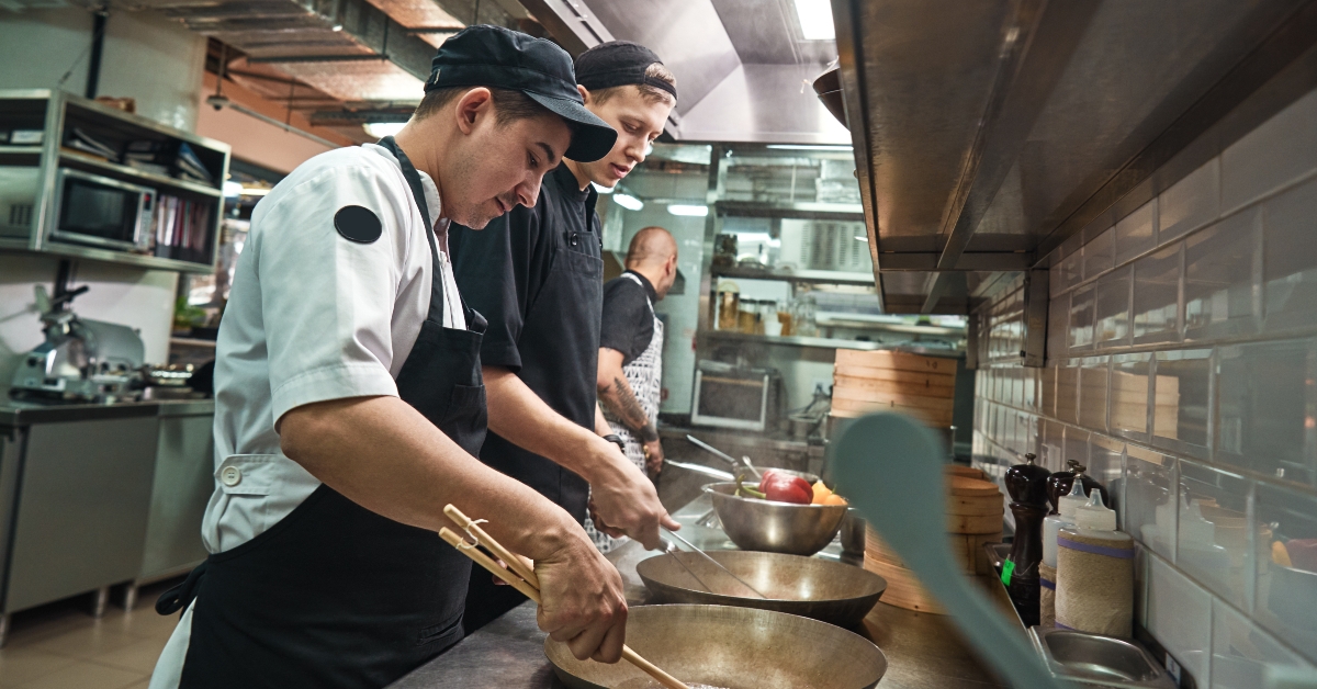 chef assistants cooking a new dish in a restaurant kitchen