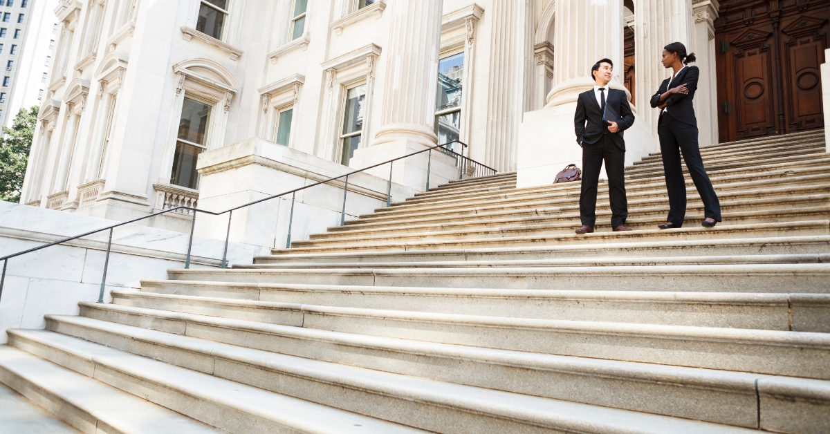 man and woman converse on the steps of a building