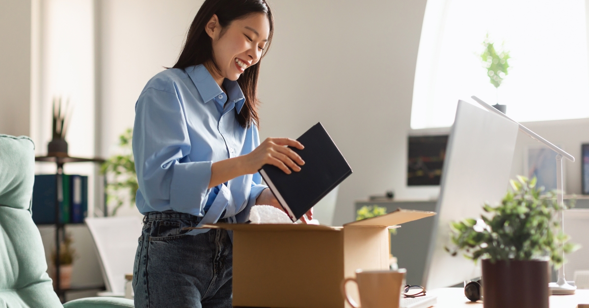 woman unpacking box at new workplace