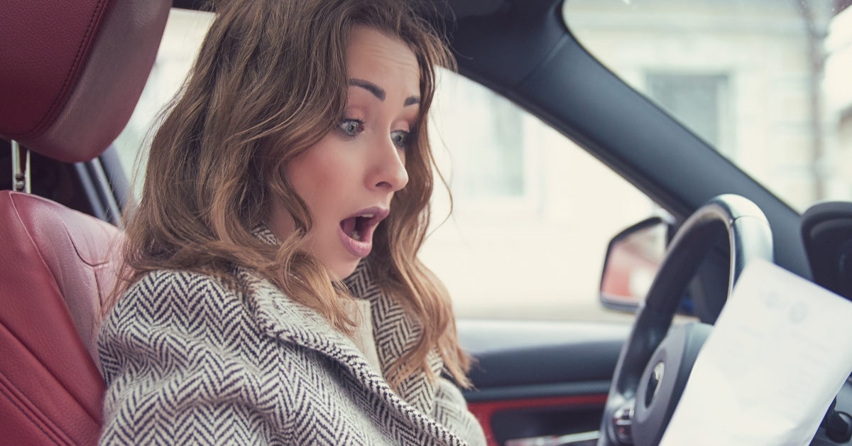 woman shocked as she read papers in her car