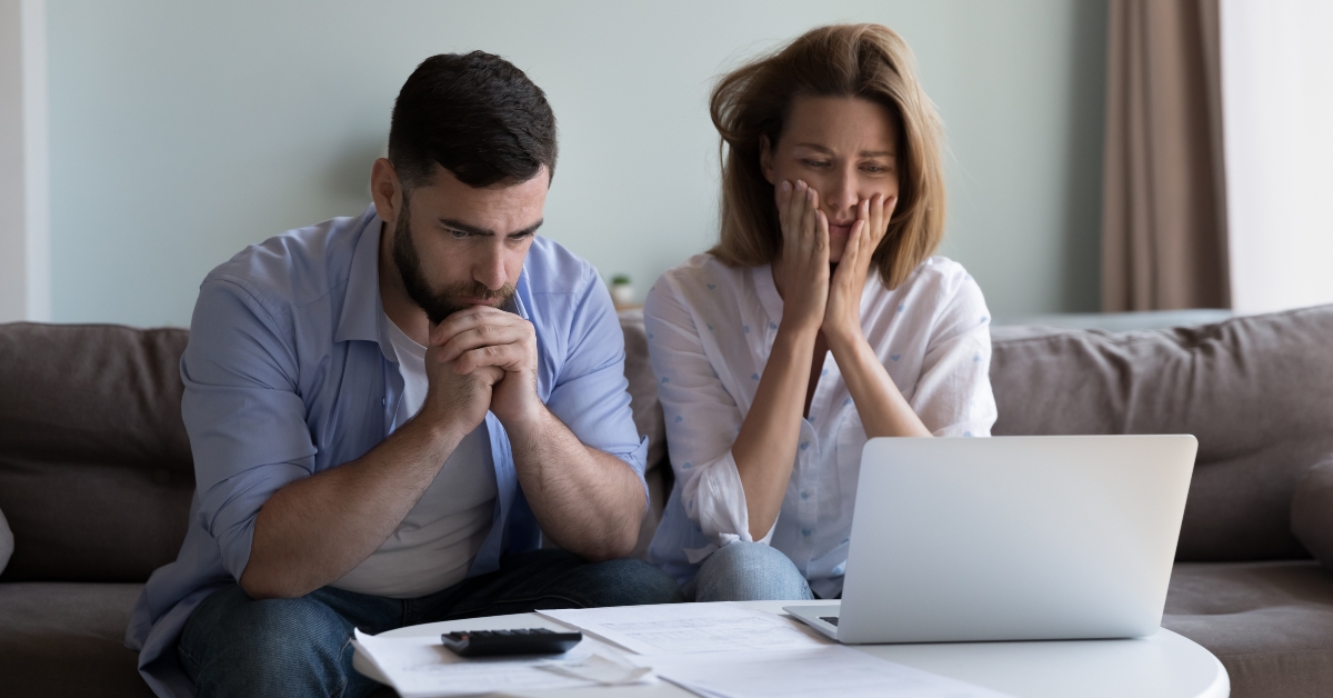 worried millennial husband and wife reading bankrupt message