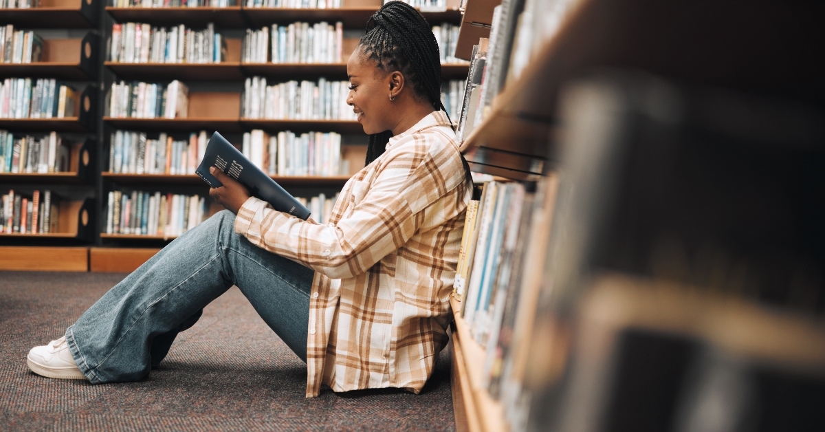 student on floor reading book studying for exam