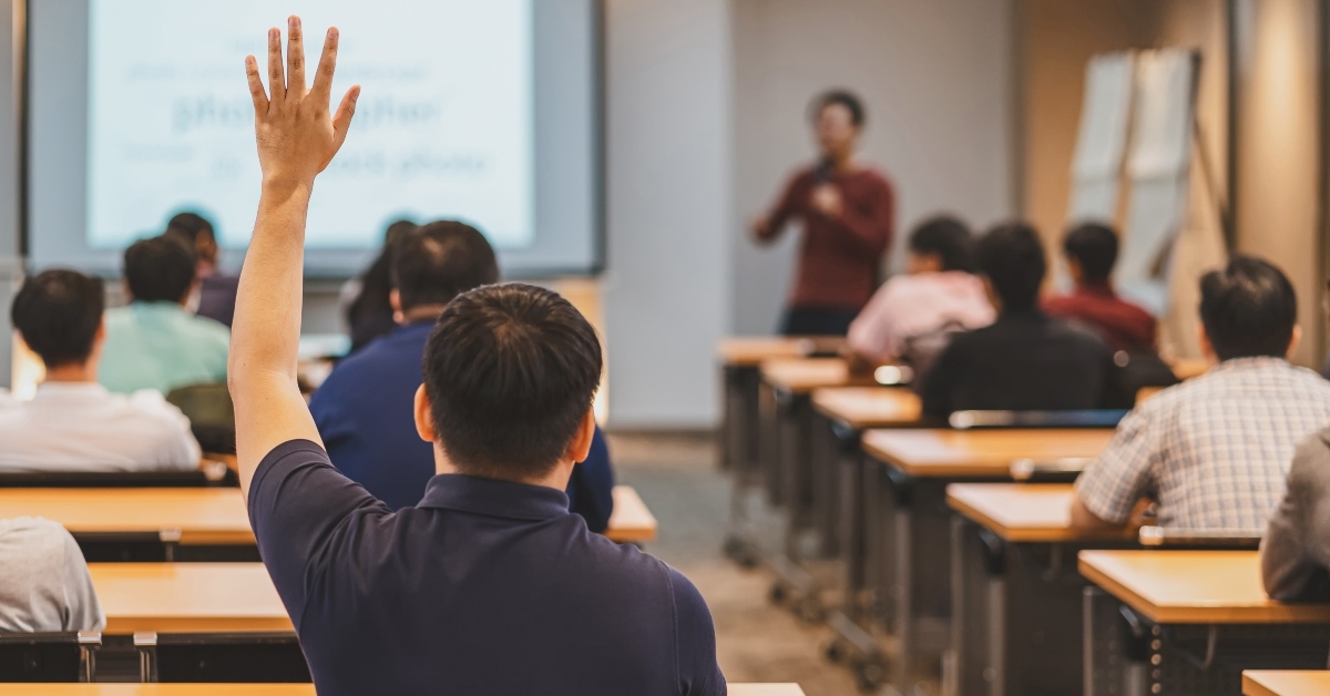 audience raises hand in response for answer the question in the meeting room