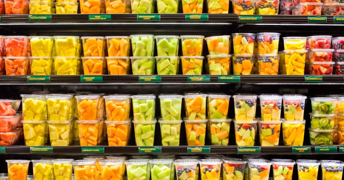 fresh cut fruits in plastic containers in supermarket