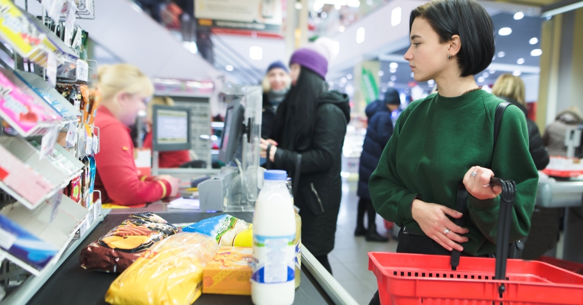 girl stands at the supermarket and waits for a queue