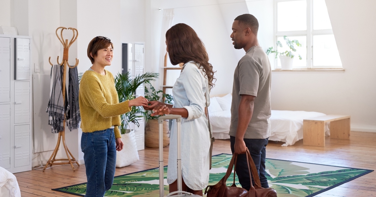excited host greets guests into stylish apartment