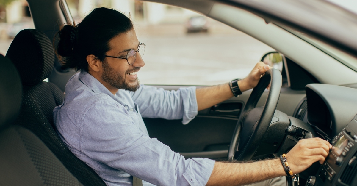guy with fastened seat belt turning on music